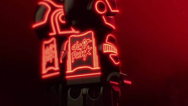 Kırmızı neon ışıklar altında Daft Punk robotlarını canlandıran LEGO minifigürleri