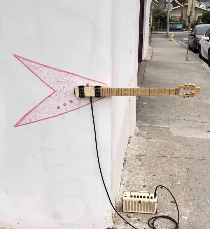 Duvar çizgisiyle birleşen elektrikli gitar yerleştirmesi