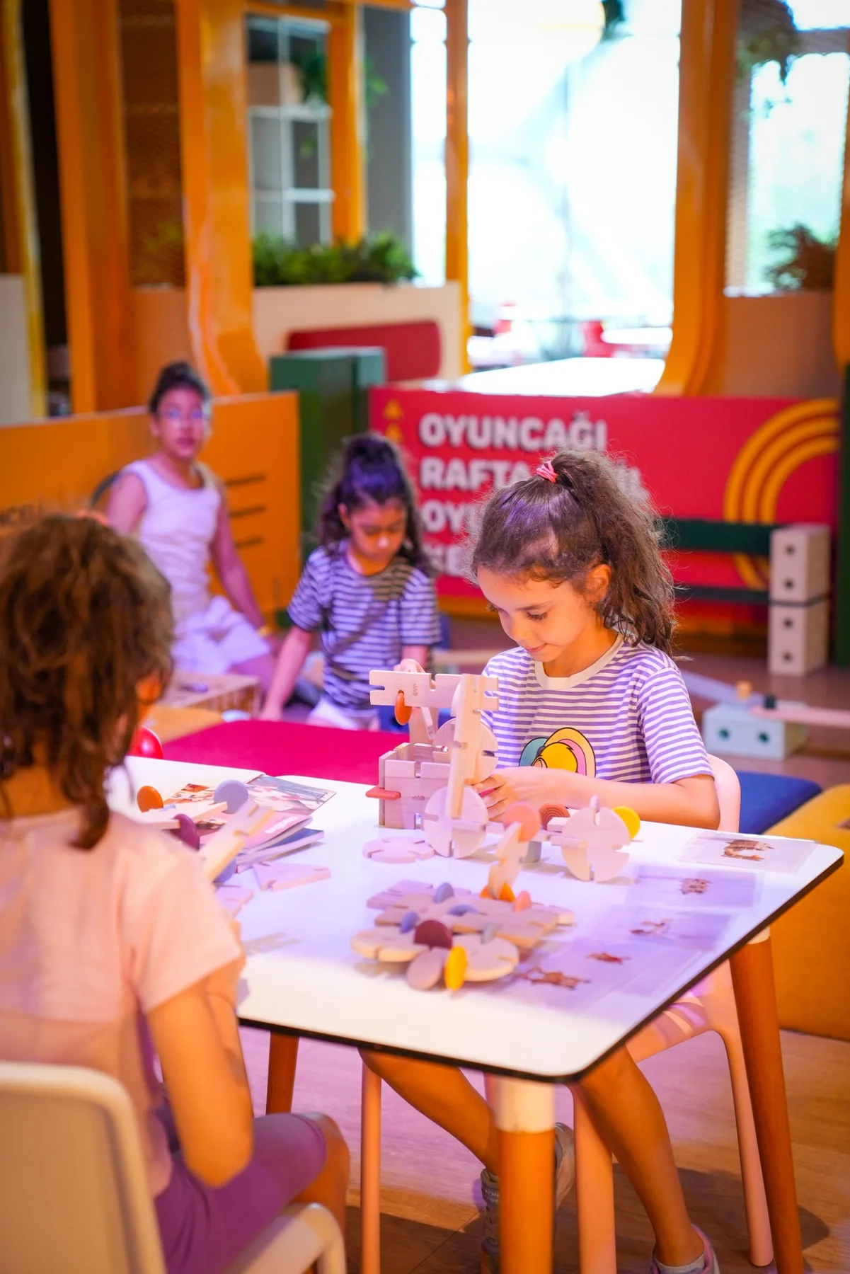 HUPALUPA STORE’da oyuncaklarla kurulan deneyim masasında oynayan çocuklar