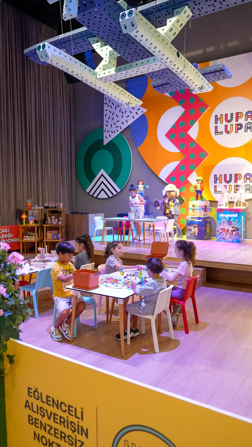 HUPALUPA STORE deneyim alanında masada oyuncaklarla oynayan çocuklar
