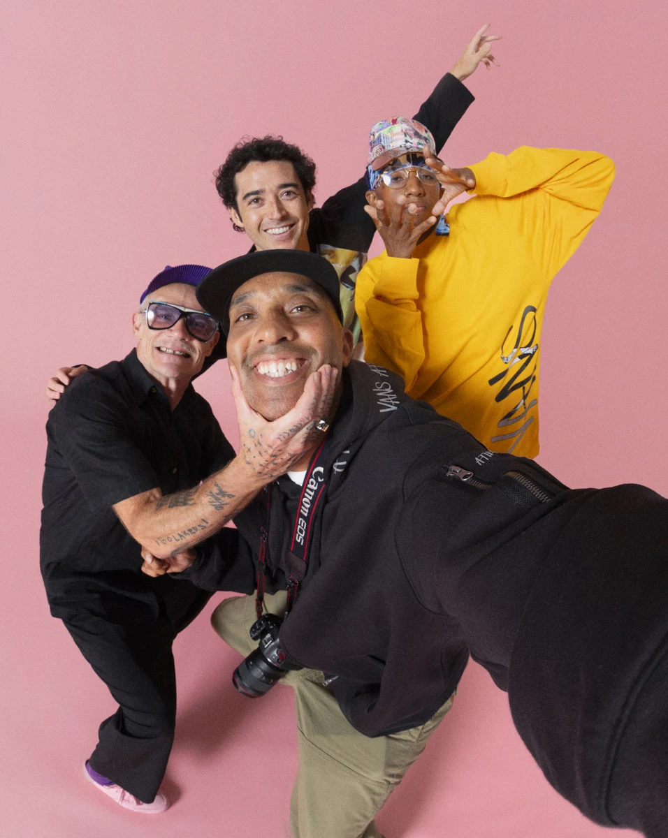 Atiba Jefferson'ın önde fotoğraf makinesiyle yer aldığı, pembe fonda dört kişinin birlikte poz verdiği kampanya fotoğrafı